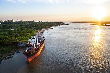 Cargo boat at sunset on the Asuncion River, Paraguay, South America 