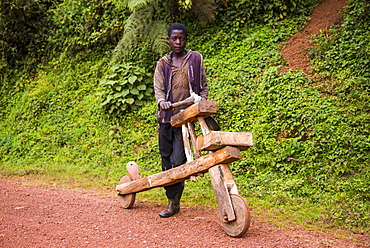 Young boy with his self made bicycle made purely out of wood, southern Uganda, East Africa, Africa