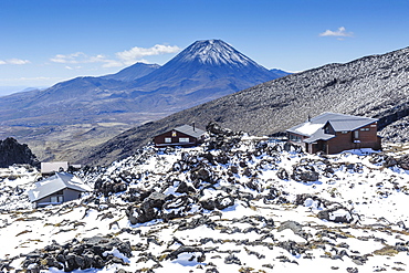 View from Mount Ruapehu of Mount Ngauruhoe with a ski cottage in the foreground, Tongariro National Park, UNESCO World Heritage Site, North Island, New Zealand, Pacific