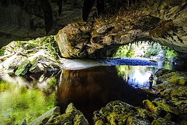 Woman enjoying the stunning Moria Gate Arch in the Oparara Basin, Karamea, West Coast, South Island, New Zealand, Pacific