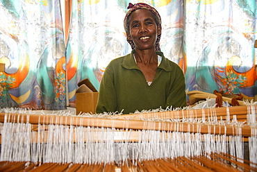 Friendly woman working on a hand weaving loom on a social project in the highlands of Eritrea, Africa