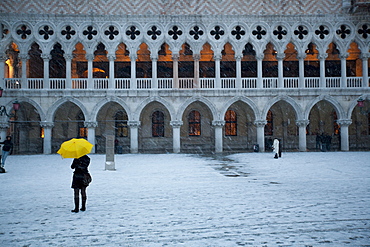 Tourist walking in St. Mark's Square during snow storm, Doge's Palace in the background, Venice, UNESCO World Heritage Site, Veneto, Italy, Europe