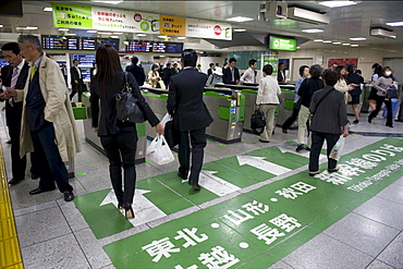 Passengers hurrying through automatic ticket wickets on their way to bullet train platforms at Tokyo Station, Japan, Asia