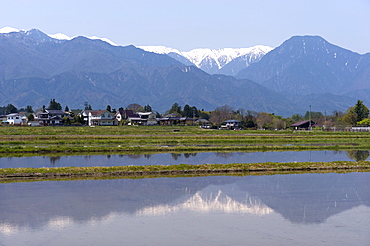 View of the Northern Alps reflected in a flooded rice paddy, Nagano Prefecture, Japan