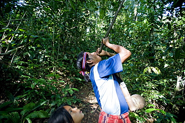 An Achuar man demonstrates using a blowgun, Amazon, Ecuador, South America