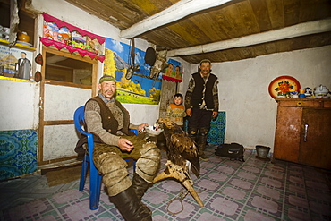 An eagle hunter at home with his eagle in Bayan Olgii, Mongolia, Central Asia, Asia