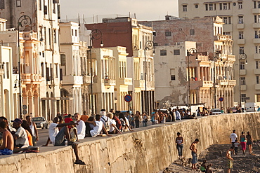 Crowds of people sitting on sea wall on the Malecon, in Havana, Cuba, West Indies, Central America