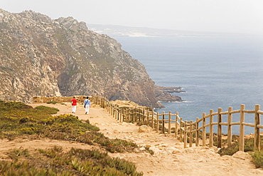 People walk along cliffs overlooking the Atlantic Ocean at Europe's most westerly point at Cabo da Roca, Portugal, Europe