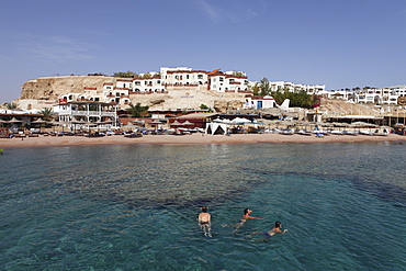 Swimmers enjoy the clear Red Sea waters at Sharks Bay, Sharm el-Sheikh, Sinai South, Egypt, North Africa, Africa