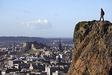 A tourist on Arthur's Seat looking towards the castle and skyline of Auld Reekie, Edinburgh, Scotland, United Kingdom, Europe