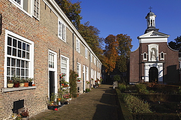 Chapel and brick housing within the courtyard of the Begijnhof (Beguinage) in Breda, Noord-Brabant, Netherlands, Europe