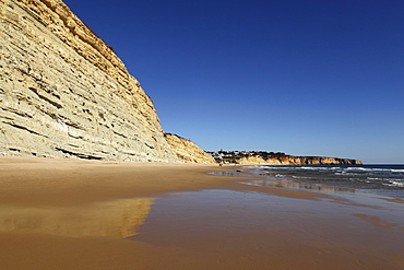 Golden sands and steep stratified cliffs, typical of the Atlantic coastline near Lagos, Algarve, Portugal, Europe