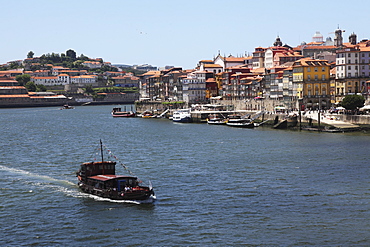 A boat cruises on the River Douro, past the Ribeira District, UNESCO World Heritage Site, Porto, Douro, Portugal, Europe