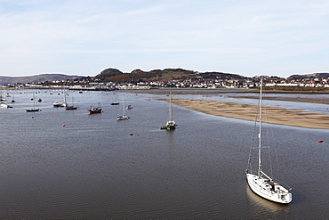 Boats float in the estuary of the River Conwy, across from Deganwy at Conwy (Conway), Wales, United Kingdom, Europe