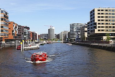 A boat on a canal in the recently developed HafenCity district of Hamburg, Germany, Europe