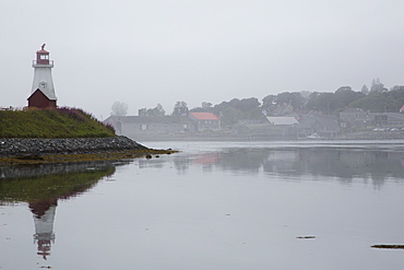 Mulholland Point Light, a lighthouse in fog, overlooking the Lubec Narrows, on Campobello Island in New Brunswick, Canada, North America