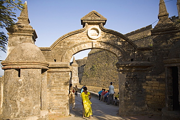 An Indian woman in a sari walks through the gate leading to the Fortress in Diu, Union Territory of Diu and Daman, India, Asia