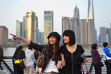 Tourists smiling and pointing, The Bund, Huangpu District, with Pudong District on the background, Shanghai, China, Asia