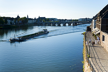 Barge on the River Maas, St. Servatius Bridge and coffee bars at Maaspuntweg riverfront, Maastricht, Limburg, The Netherlands, Europe