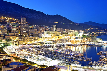 Dusk view across Port Hercule and the city and Principality of Monaco, Cote d'Azur, French Riviera, Mediterranean, Europe