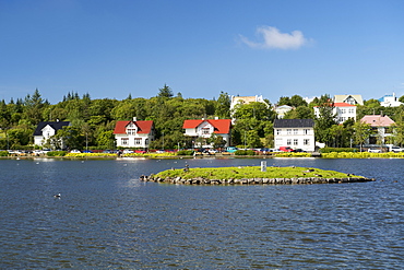 Houses seen across (Lake) Tjorn, Reykjavik, Iceland, Polar Regions