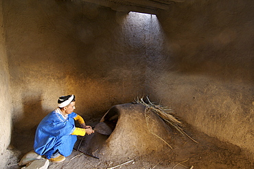 A berber man next to the oven in the kitchen of a house in Merzouga, a traditional Berber village in eastern Morocco