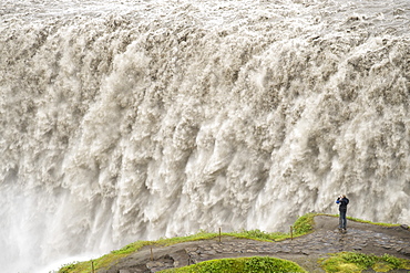 Tourist photographing Dettifoss waterfall near Myvatn in Vatnajokull National Park, northeast area, Iceland, Polar Regions