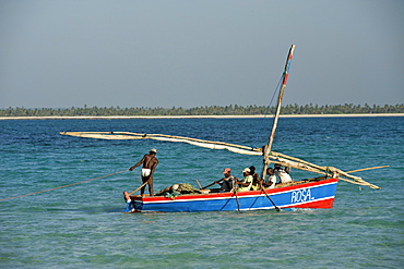 Fishermen and their dhow off the coast of Mogundula island in the Quirimbas archipelago in northern Mozambique, Indian Ocean, Africa