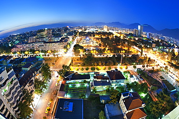 Dusk view of city with Rinia Park in the centre, Tirana, Albania, Europe