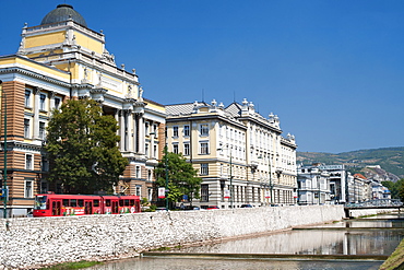 Buildings along Obala Kulina Bana road on the north bank of the Miljacka River in Sarajevo, capital of Bosnia and Herzegovina, Europe