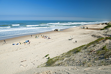 Surfers and the remains of World War II blockhouses on Le Pin Sec beach in the Aquitaine region of southwestern France, Europe