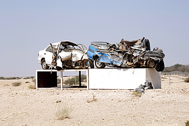 Car wrecks placed on display along the road side in Qatar as a warning to other drivers.