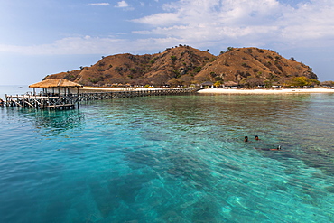 Three boys swimming in the waters off the western coast of Flores island, Indonesia.