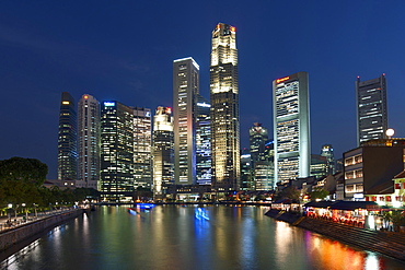 Boat Quay and the Singapore skyline and river at dusk.