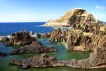 Kids swimming in the sea at Porto Moniz on the island of Madeira.