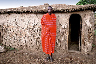 Portrait of a Maasai man outside his hut in his village (manyatta) in the Masai Mara, Kenya, East Africa, Africa