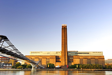 Early morning view of the Tate Modern art Gallery and Millenium Bridge taken from across the Thames River in London. The Tate Modern is the converted former Bankside power station on the south bank of the Thames River. It was built in two phases between 1947 and 1963 and was designed by Sir Giles Gilbert Scott.