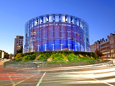 London's IMAX cinema and passing traffic at dusk.