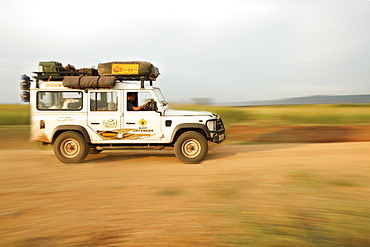 Land Rover Defender driving through the Kabwoya Wildlife Reserve in western Uganda.