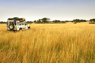 Land Rover Defender driving through the plains at Pelican Point in Queen Elizabeth National Park in western Uganda.