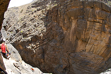 Hikers doing the Via Ferrata hike in Snake Canyon, part of Wadi Bani Auf in Jebel Akhdar of the western Hajar mountains in Oman.