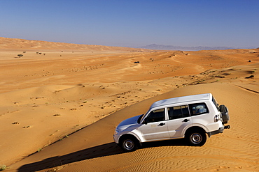 4WD in the dunes of Wahiba Sands (Ramlat al Wahaybah) in Oman.