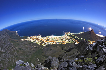 Night-time, moonlit view of the Twelve Apostles range of Table Mountain, Camps bay, the Atantic Ocean and Lion's Head in Cape Town, South Africa.