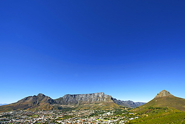 View of Table Mountain, Devil's Peak (left), Lion's Head (right) and the city of Cape Town on a cloudless summer day.