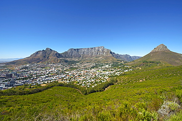 View of Table Mountain, Devil's Peak (left), Lion's Head (right) and the city of Cape Town on a cloudless summer day.