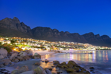 Night time view of Camps Bay, Camps Bay beach and the Twelve Apostles mountains in Cape Town.