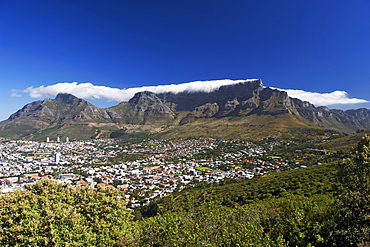 View of the city of Cape Town surrounded by Table Mountain on which the clouds form the well-known 'table cloth'.