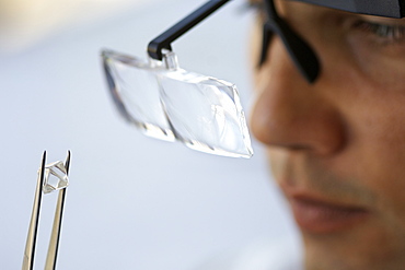 An uncut diamond being examined during sorting at De Beers' Harry Oppenheimer House building in Kimberley South Africa.