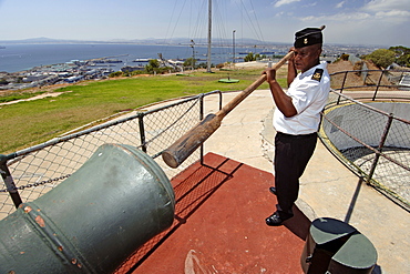 Chief Petty Officer Dudley Malgas using a wooden ram rod to push the charge into the muzzle of the noon gun cannon in Cape Town.
The daily noon gun is Cape Town’s oldest living tradition and the two cannons used are the oldest guns in daily use in the world. They have marked the midday hour in the mother city in this distinctive, albeit noisy manner since early 1806. The cannons were cast in Britain in 1794 and still bear the royal crest of King George the third. The firing of the cannon was originally to give ships in the bay a means of re-setting their clocks accurately.