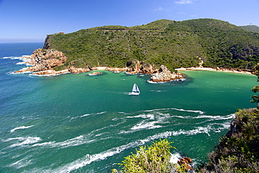 A catamaran sails through The Heads, the entrance to the Knysna lagoon on the Garden Route in South Africa.